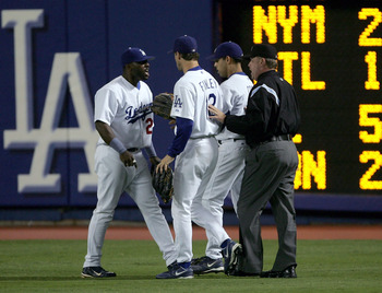 LOS ANGELES - SEPTEMBER 28:  Right fielder Milton Bradley #21 of the Los Angeles Dodgers is restrained by Steve Finley #12, Alex Cora #3 and umpire Jim Joyce after an incident with a fan after Bradley's error against the Colorado Rockies allowed two runs