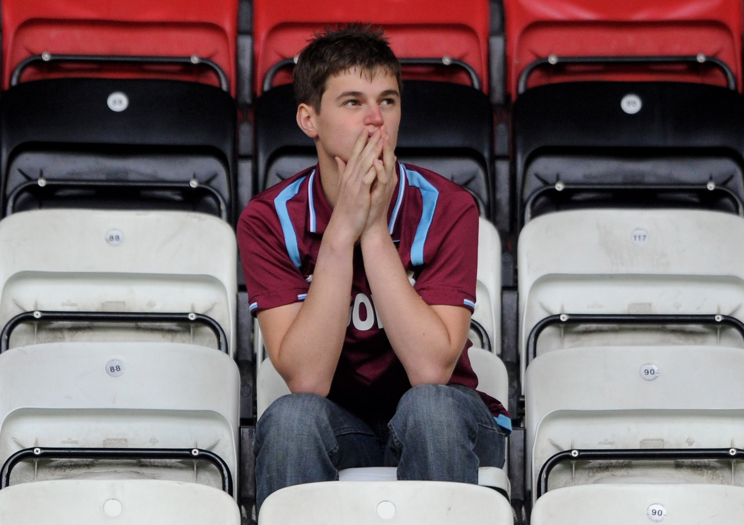 WIGAN, ENGLAND - MAY 15:  A West Ham United fan looks dejected following his team's relegation at the end of the Barclays Premier League match between Wigan Athletic and West Ham United at the DW Stadium on May 15, 2011 in Wigan, England.  (Photo by Chris