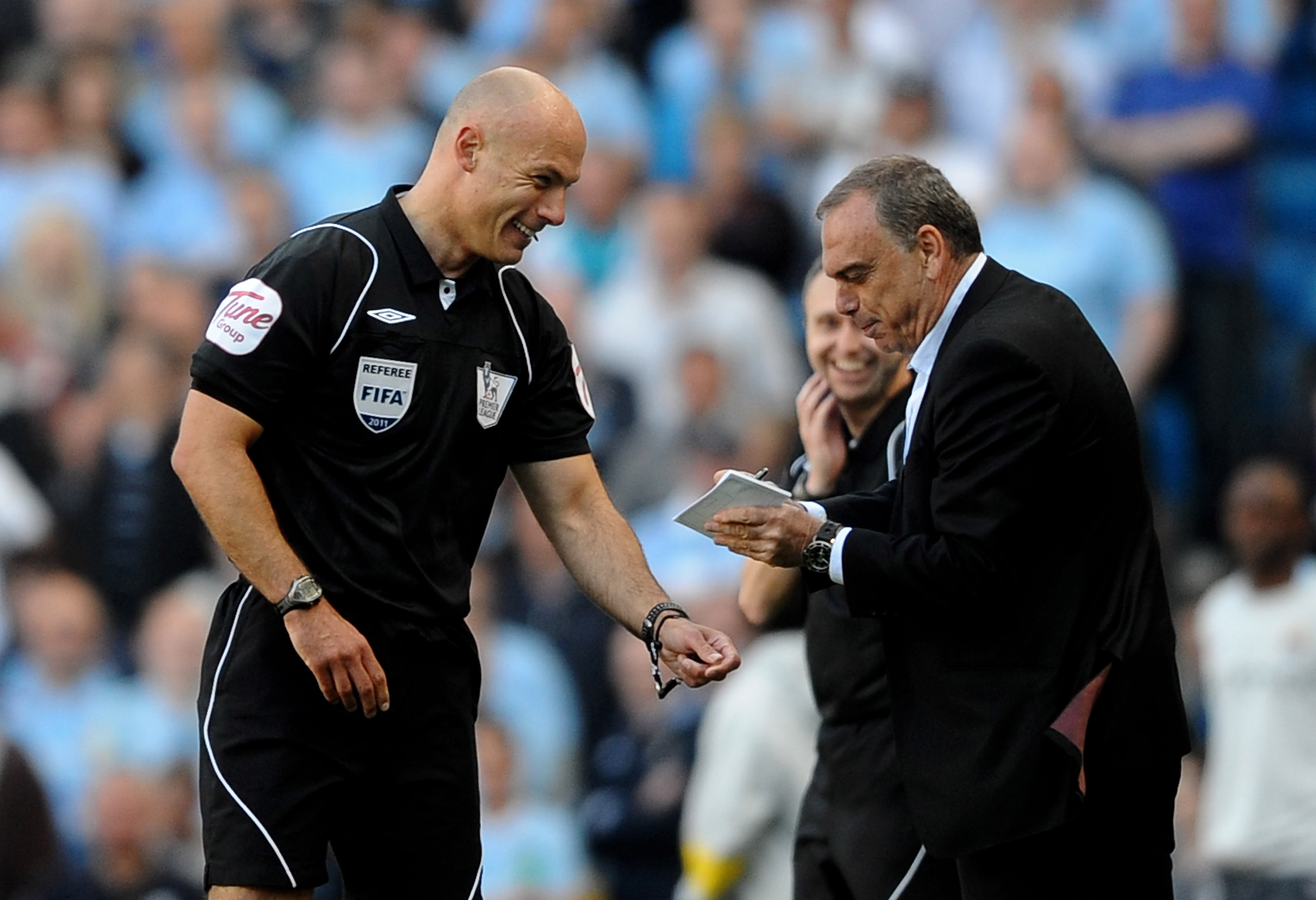 MANCHESTER, ENGLAND - MAY 01:  West Ham United Manager Avram Grant pretends to sign an autograph for Referee  Howard Webb after he dropped his notebook during the Barclays Premier League match between Manchester City and West Ham United at the City of Man
