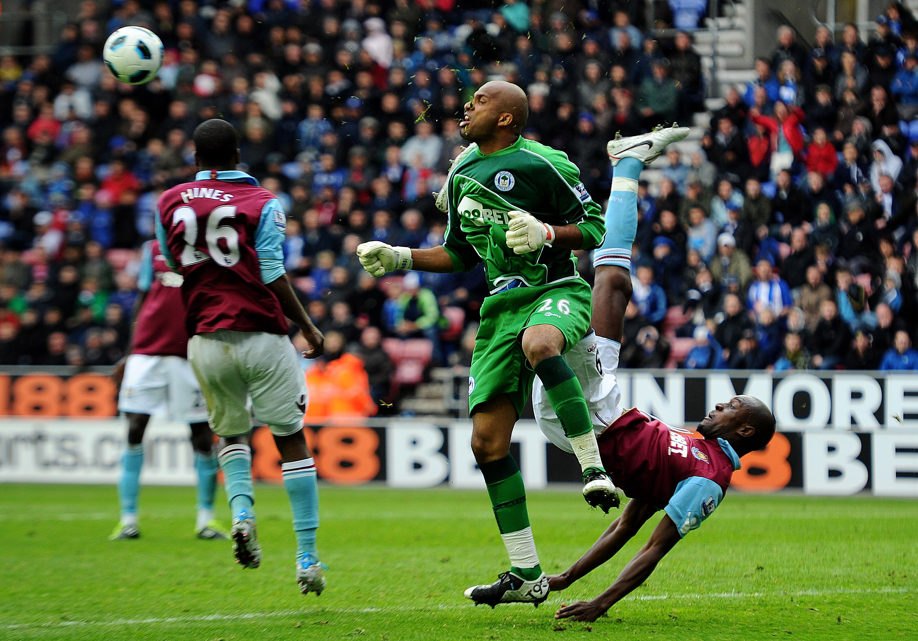 WIGAN, ENGLAND - MAY 15:  Ali Al Habsi of Wigan Athletic tangles with Carlton Cole of West Ham United during the Barclays Premier League match between Wigan Athletic and West Ham United at the DW Stadium on May 15, 2011 in Wigan, England.  (Photo by Clive