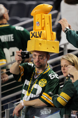 Two Green Bay Packers fans wear different style cheese head hats