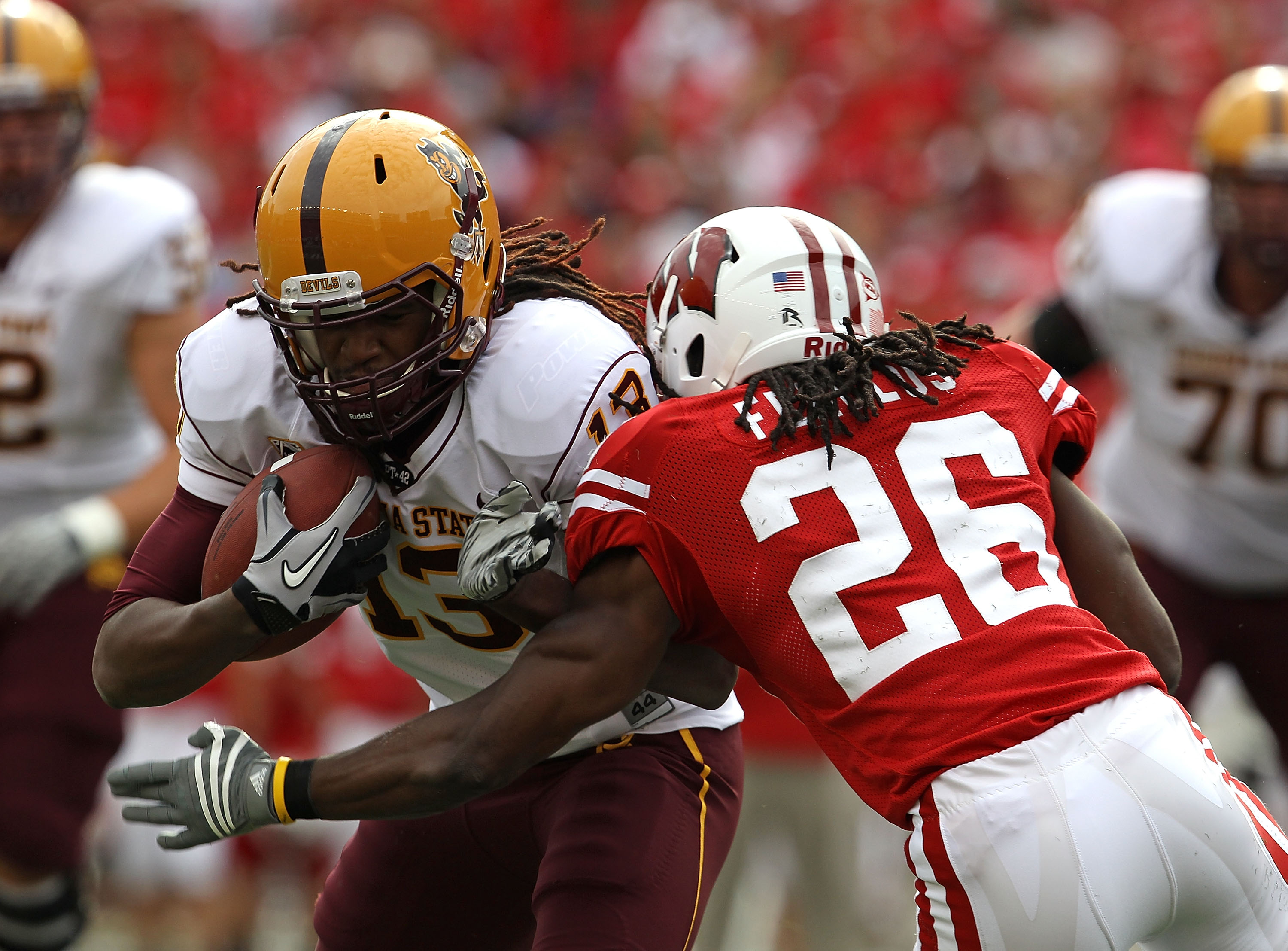 MADISON, WI - SEPTEMBER 18: George Bell #13 of the Arizona State Sun Devils looks for running room after catching a pass for a first down as Antonio Fenelus #26 of the Wisconsin Badgers closes in at Camp Randall Stadium on September 18, 2010 in Madison, W