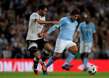 MANCHESTER, ENGLAND - MAY 10:  Carlos Tevez of Manchester City competes with Sandro of Tottenham Hotspur during the Barclays Premier League match between Manchester City and Tottenham Hotspur at the City of Manchester Stadium on May 10, 2011 in Manchester