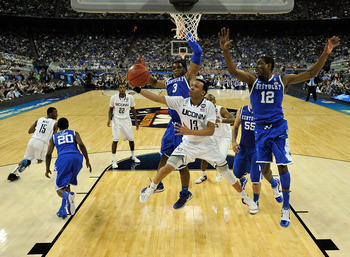 HOUSTON, TX - APRIL 02:  Shabazz Napier #13 of the Connecticut Huskies goes to the hoop against Terrence Jones #3 and Brandon Knight #12 of the Kentucky Wildcats during the National Semifinal game of the 2011 NCAA Division I Men's Basketball Championship