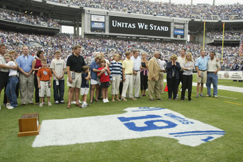 BALTIMORE - SEPTEMBER  15:  Family and friends pay tribute to Johnny Unitas as they stand behind a jersey painted with his name and uniform number on the grass prior to the game between the Tampa Bay Buccaneers and the Baltimore Ravens on September 15, 20