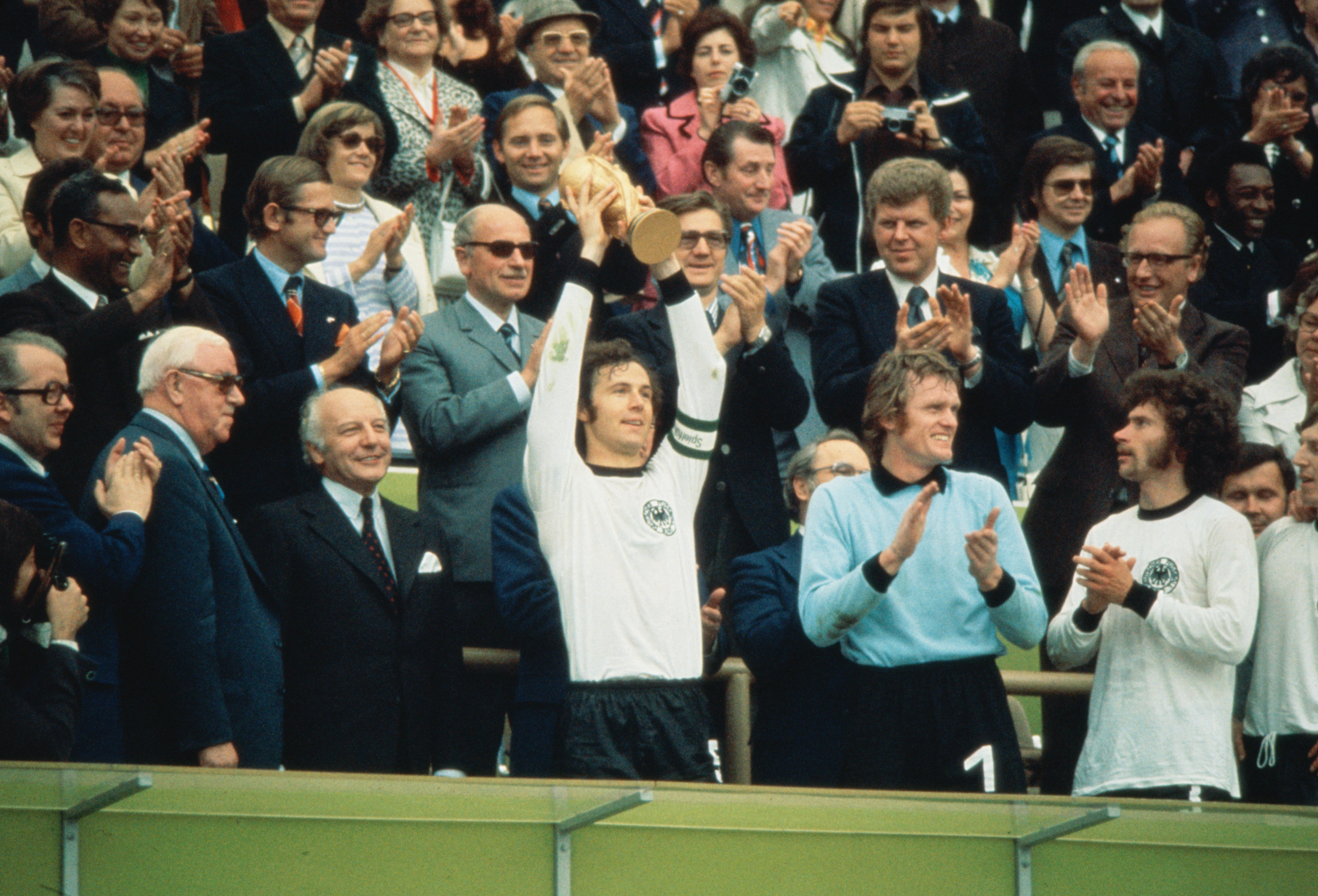 7 Jul 1974:  Franz Beckenbauer (centre) of Germany becomes the first Captain to lift the new FIFA trophy after leading his side to victory over Holland in the World Cup Final at the Olympic Stadium in Munich, Germany. Germany won the match 2-1. \ Mandator