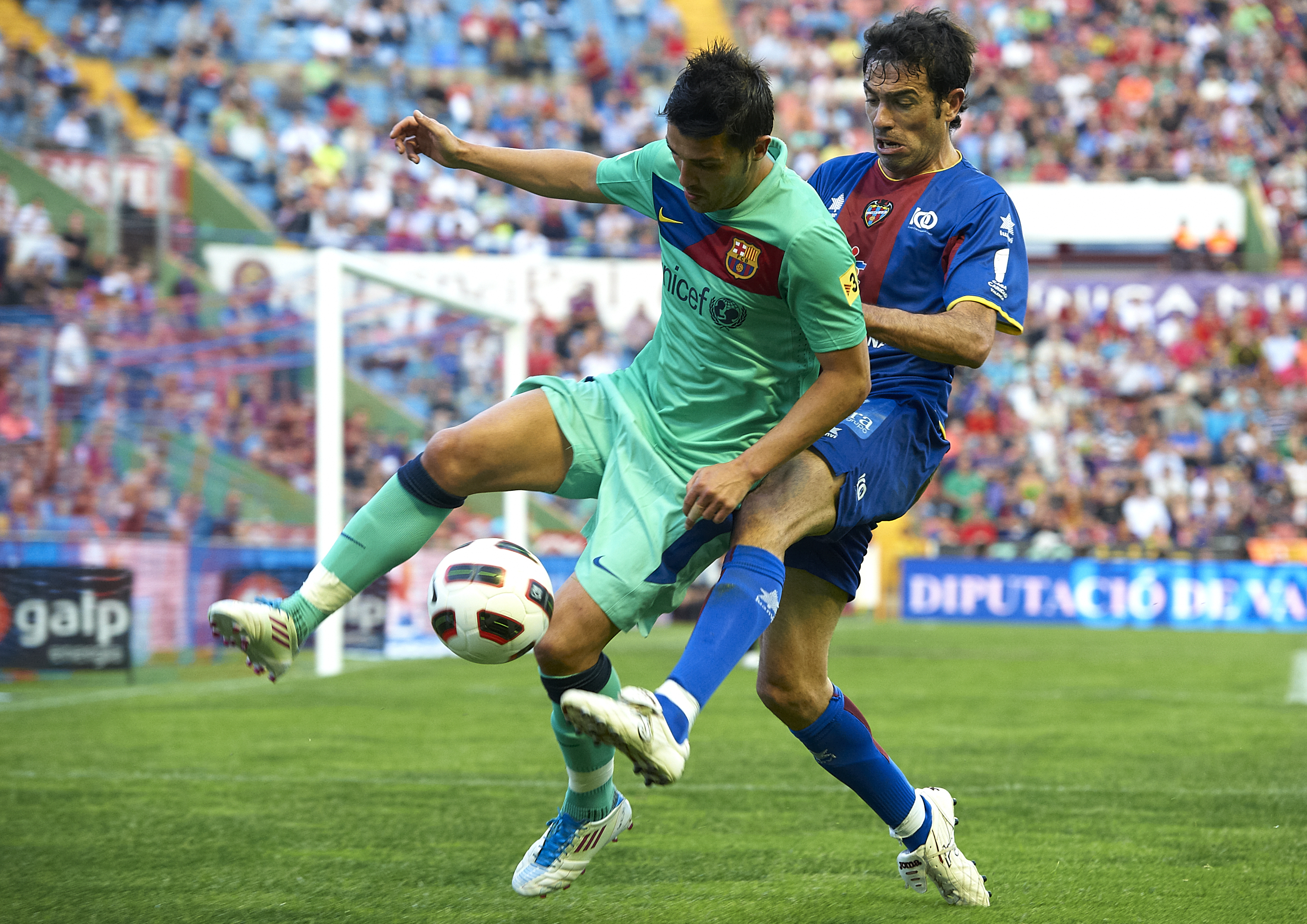 VALENCIA, SPAIN - MAY 11:  David Villa (L) of Barcelona is tackled by Javi Venta of Levante during the La Liga match between Levante UD and Barcelona at Ciutat de Valencia on May 11, 2011 in Valencia, Spain. The match ended 1-1.  (Photo by Manuel Queimade