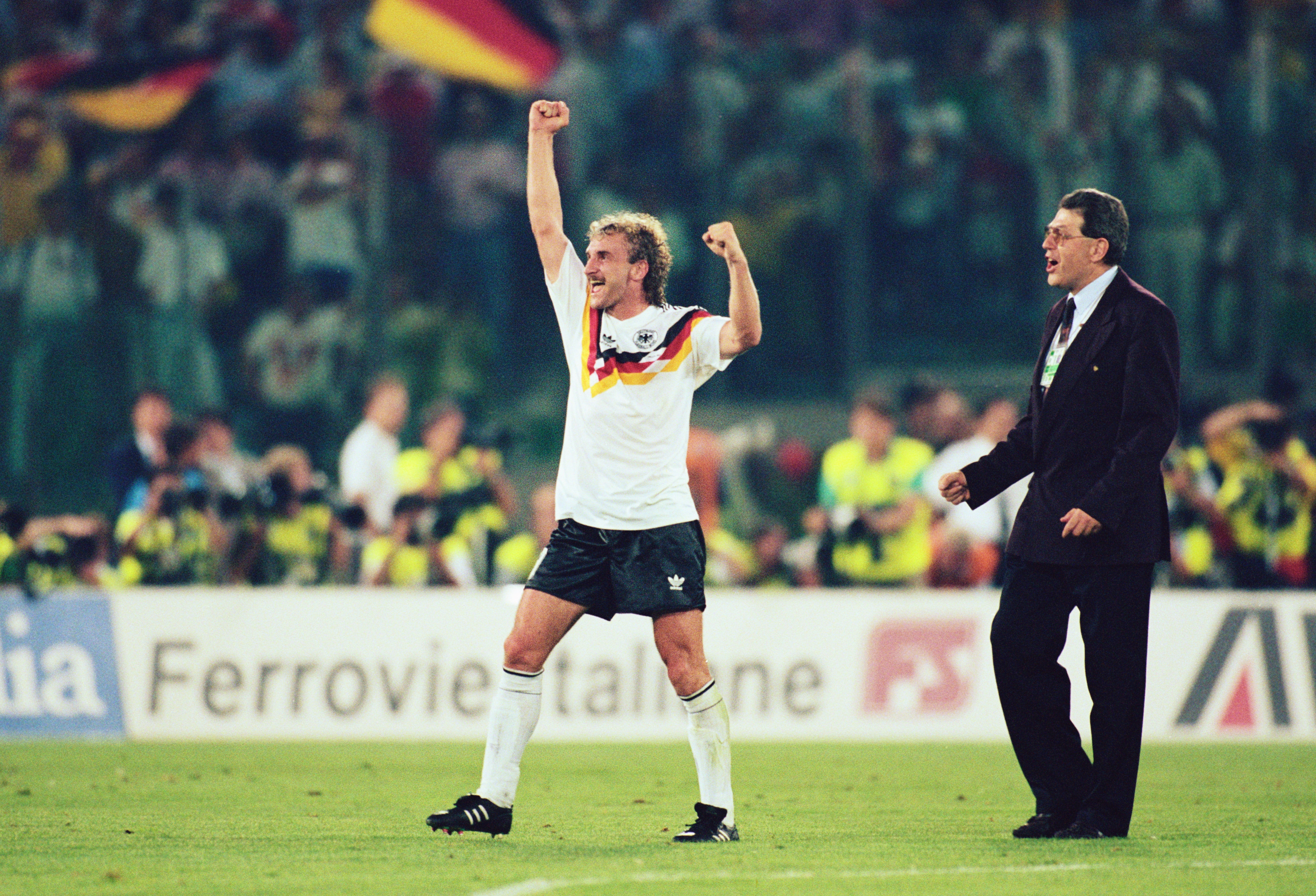 8 JUL 1990: RUDI VOELLER OF GERMANY WAVES HIS FIST IN CELEBRATION AS GERMAN FLAGS WAVE IN THE CROWD BEHIND HIM AFTER GERMANY WIN THE 1990 SOCCER WORLD CUP FINAL1-0 AGAINST ARGENTINA. Mandatory Credit: Simon Bruty/ALLSPORT