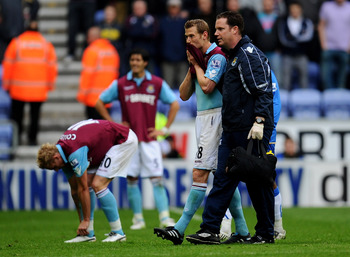 WIGAN, ENGLAND - MAY 15: Jonathan Spector of West Ham United looks dejected following his team's relegation at the end of the Barclays Premier League match between Wigan Athletic and West Ham United at the DW Stadium on May 15, 2011 in Wigan, England. (