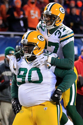 CHICAGO, IL - JANUARY 23:  B.J. Raji #90 of the Green Bay Packers reacts with teammate Sam Shields #37 after scoring on a 18-yard interception return for a touchdown in the fourth quarter against the Chicago Bears in the NFC Championship Game at Soldier F