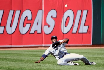 OAKLAND, CA - APRIL 3: Milton Bradley #15 of the Seattle Mariners makes a sliding catch in left-field against the Oakland Athletics during a MLB baseball game at the Oakland-Alameda County Coliseum April 3, 2011 in Oakland, California. (Photo by Thearon