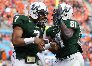 CHARLOTTE, NC - DECEMBER 31:  B.J. Daniels #7 of the USF Bulls celebrates after scoring a touchdown with teammate Dontavia Bogan #81 against the Clemson Tigers during their game at Bank of America Stadium on December 31, 2010 in Charlotte, North Carolina.