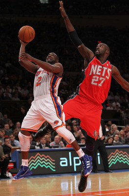 Photo: New Jersey Nets' Damion James is helped up by teammate