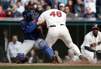 CLEVELAND, OH- APRIL 12: Taylor Teagarden #2 of the Texas Rangers tags out Travis Hafner #48 of the Cleveland Indians while colliding with him at home plate during the Opening Day game on April 12, 2010 at Progressive Field in Cleveland, Ohio.  (Photo by