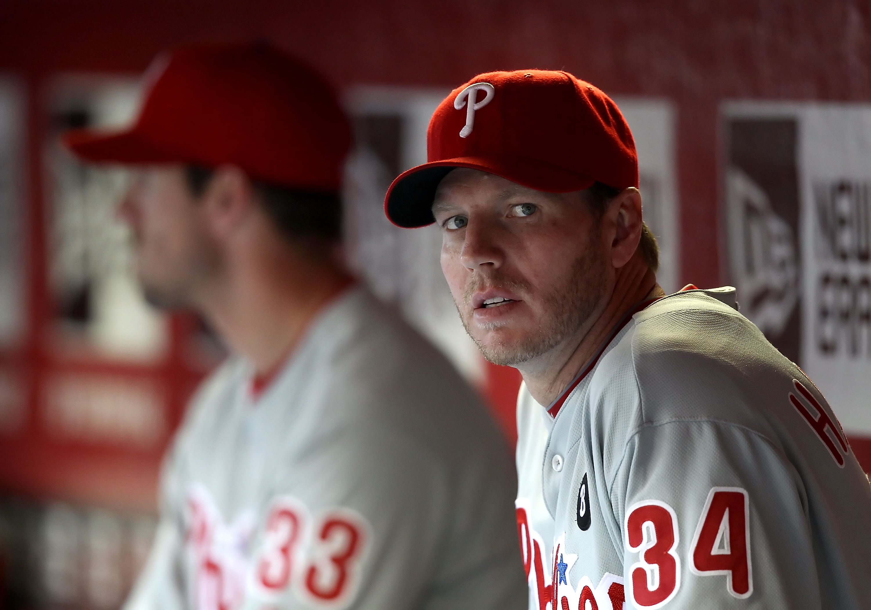 PHOENIX, AZ - APRIL 26:  Pitcher Roy Halladay #34 (R) and Cliff Lee #33 of the Philadelphia Phillies sit in the dugout during the Major League Baseball game against the Arizona Diamondbacks at Chase Field on April 26, 2011 in Phoenix, Arizona.  (Photo by