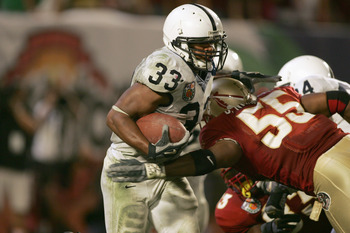 MIAMI GARDENS, FL - JANUARY 3:  Austin Scott #33 of the Penn State Nittany Lions carries the ball as he is tackled by Derek Nicholson #55 of the Florida State Seminoles during the 72nd Fed Ex Orange Bowl at Dolphins Stadium on January 3, 2005 in Miami Gar