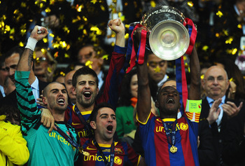 LONDON, ENGLAND - MAY 28:  (L-R) Victor Valdes, Gerard Pique and Xavi celebrate as teammate Eric Abidal of FC Barcelona lifts the trophy during the UEFA Champions League final between FC Barcelona and Manchester United FC at Wembley Stadium on May 28, 201