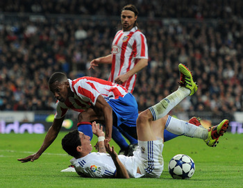 MADRID, SPAIN - JANUARY 13:  Luis Perea (L) of Atletico Madrid fouls Angel Di Maria of Real Madrid during the quarter-final Copa del Rey first leg match between Real Madrid and Atletico Madrid at Estadio Santiago Bernabeu on January 13, 2011 in Madrid, Sp