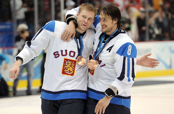 VANCOUVER, BC - FEBRUARY 27:  Mikko Koivu #9 and Teemu Selanne #8 of Finland celebrates with his bronze medal after the ice hockey men's bronze medal game between Finland and Slovakia on day 16 of the Vancouver 2010 Winter Olympics at Canada Hockey Place