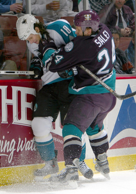 SAN DIEGO - DECEMBER 10: Mike Ricci #19 of the San Jose Sharks is checked by Ruslan Salei #24 of the Anaheim Mighty Ducks during the 2nd period of their NHL game on December 10, 2003 at the Arrowhead Pond in Anaheim, California. (Photo by Donald Miralle