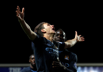 BLACKBURN, ENGLAND - APRIL 25:  Edin Dzeko of Manchester City celebrates scoring the opening goal with team mate Mario Balotelli during the Barclays Premier League match between Blackburn Rovers and Manchester City at Ewood Park on April 25, 2011 in Black