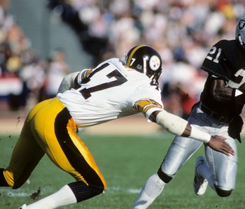 LOS ANGELES, CA - JANUARY 1:  Cliff Branch #21 of the Los Angeles Raiders runs the ball against Mel Blount #47 of the Pittsburgh Steelers during the AFC Divisional playoff game at the Los Angeles Memorial Coliseum on January 1, 1984 in Los Angeles, Califo