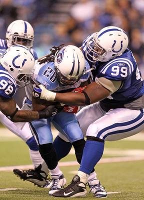 INDIANAPOLIS - JANUARY 02:  Chris Johnson #28 of the Tennessee Titans is tackled by Robert Mathis #98 and Antonio Johnson #99 of the Indianapolis Colts at Lucas Oil Stadium on January 2, 2011 in Indianapolis, Indiana.  the Colts won 23-20.  (Photo by Andy
