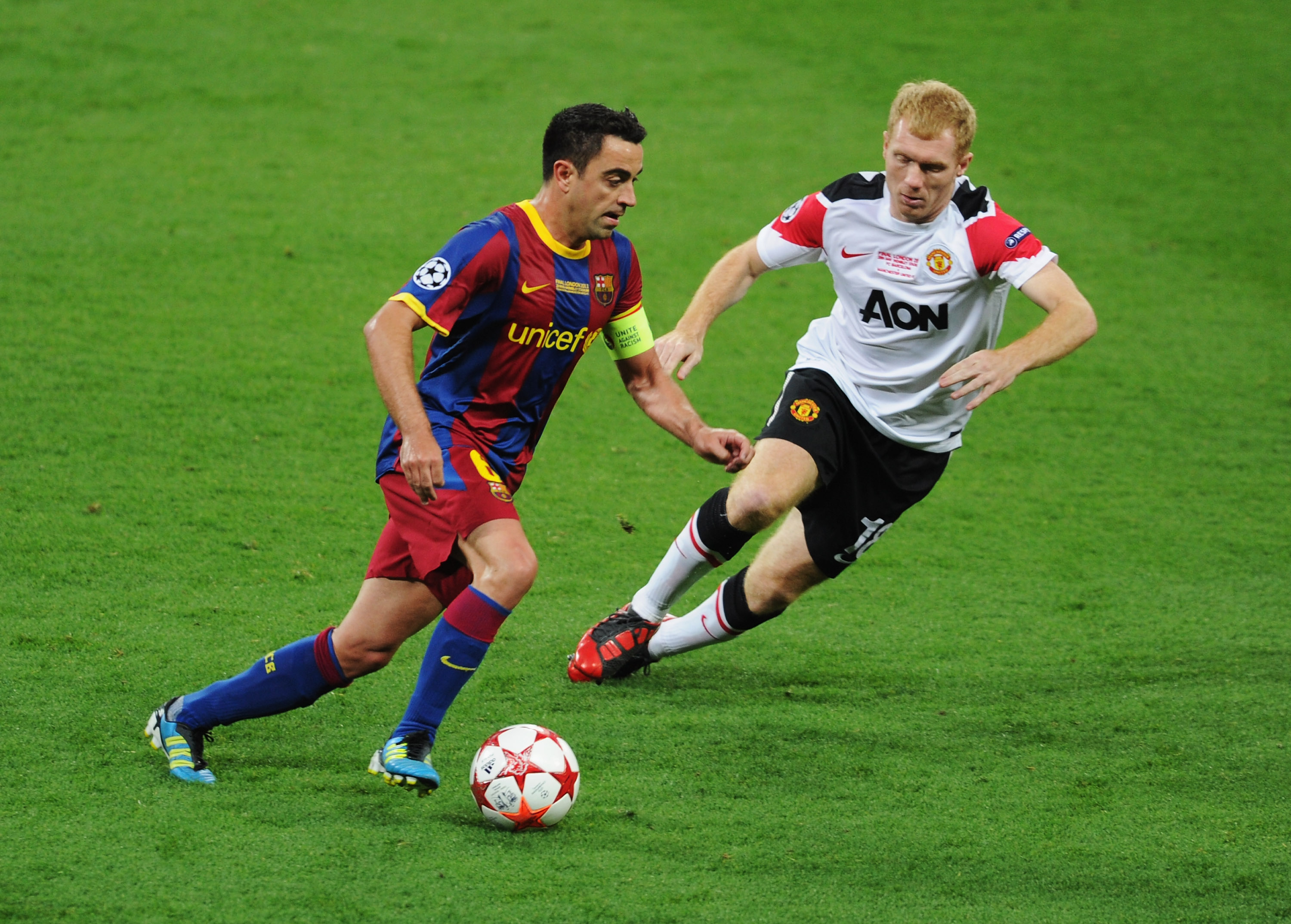 LONDON, ENGLAND - MAY 28:  Xavi of FC Barcelona is watched by Paul Scholes of Manchester United during the UEFA Champions League final between FC Barcelona and Manchester United FC at Wembley Stadium on May 28, 2011 in London, England.  (Photo by Michael