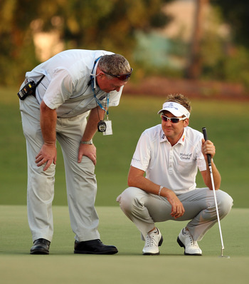 DUBAI, UNITED ARAB EMIRATES - NOVEMBER 28:  Ian Poulter of England with refree Andy McFee as a penlaty shot is called during the second play-off hole during the play-off during the final round of the Dubai World Championship on the Earth Course, Jumeirah 