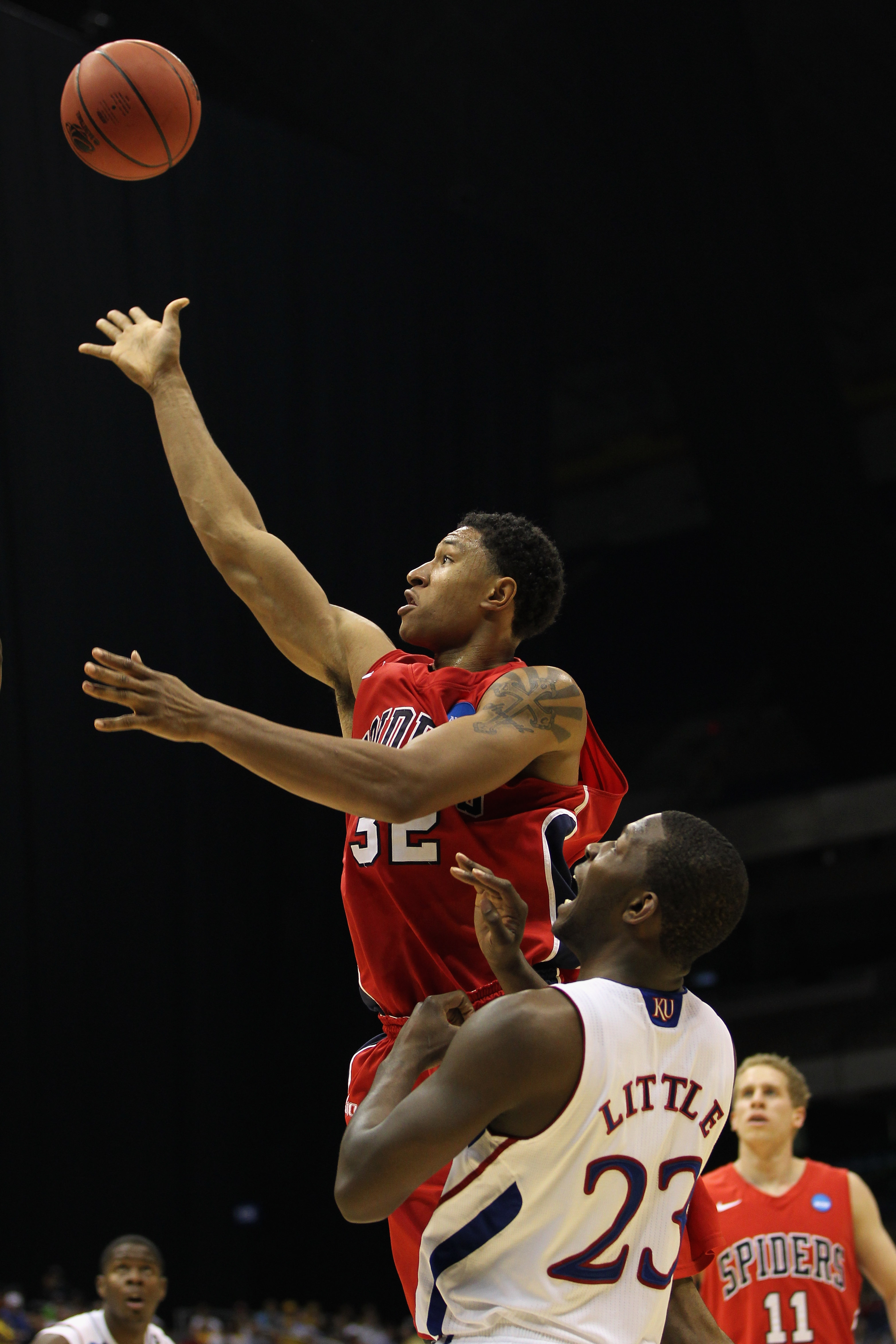 SAN ANTONIO, TX - MARCH 25:  Justin Harper #32 of the Richmond Spiders puts up a shot against Mario Little #23 of the Kansas Jayhawks during the southwest regional of the 2011 NCAA men's basketball tournament at the Alamodome on March 25, 2011 in San Anto