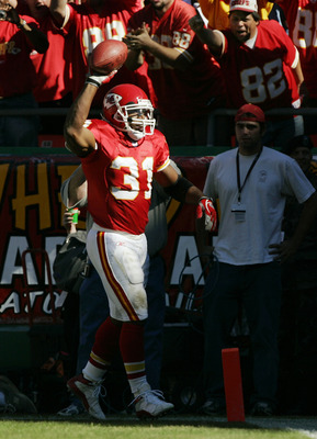 Priest Holmes of the Kansas City Chiefs runs the ball past Jason