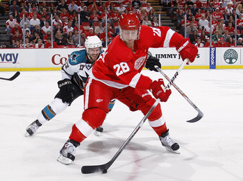DETROIT - MAY 6: Brian Rafalski #28 of the Detroit Red Wings controls the puck in front of Torrey Mitchell #17 of the San Jose Sharks during the third period in Game Four of the Western Conference Semifinals during the 2011 NHL Stanley Cup Playoffs on May
