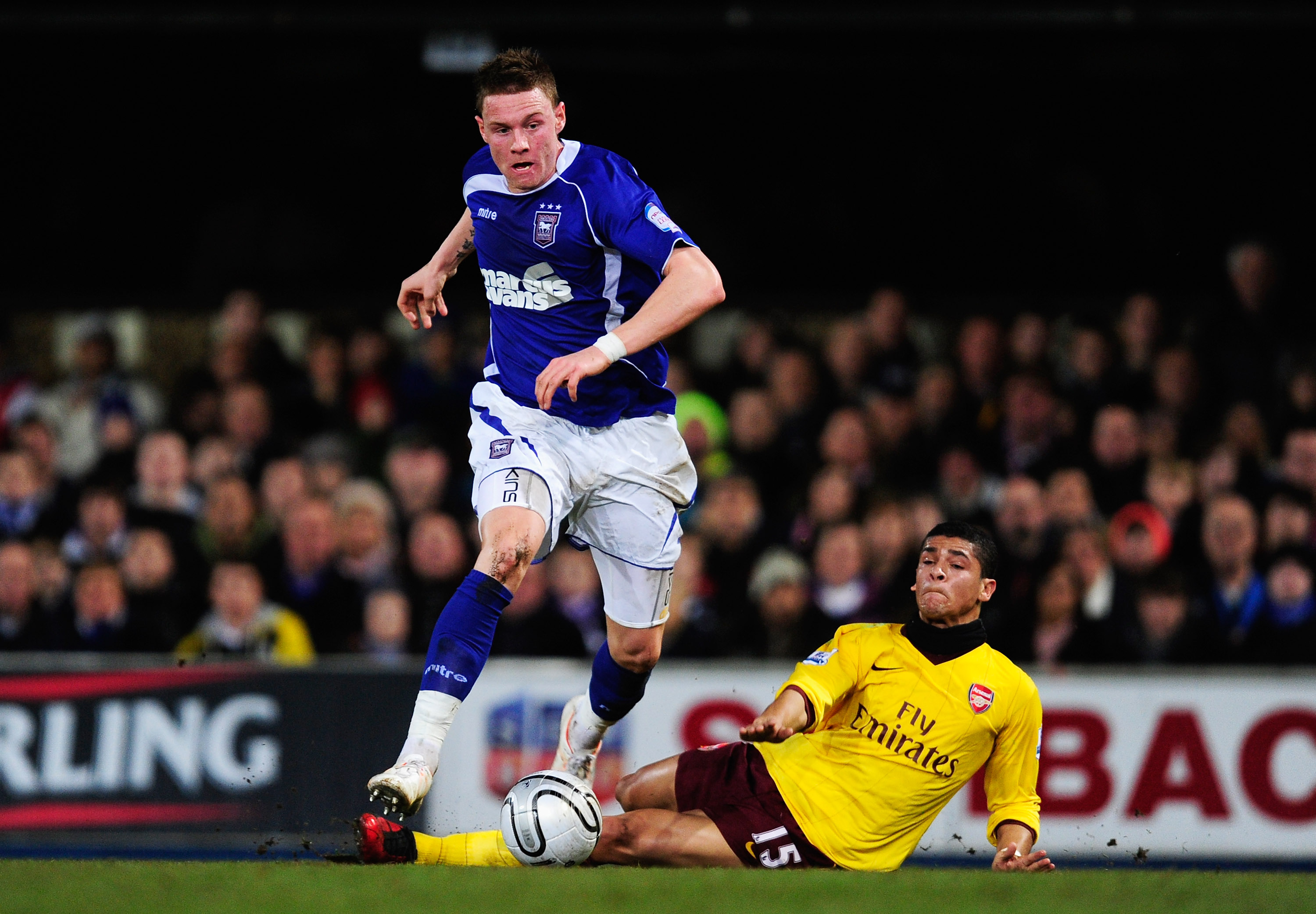 IPSWICH, ENGLAND - JANUARY 12: Connor Wickham of Ipswich Town is challenged by Denilson of Arsenal during the Carling Cup Semi Final First Leg match between Ipswich Town and Arsenal at Portman Road on January 12, 2011 in Ipswich, England.  (Photo by Jamie