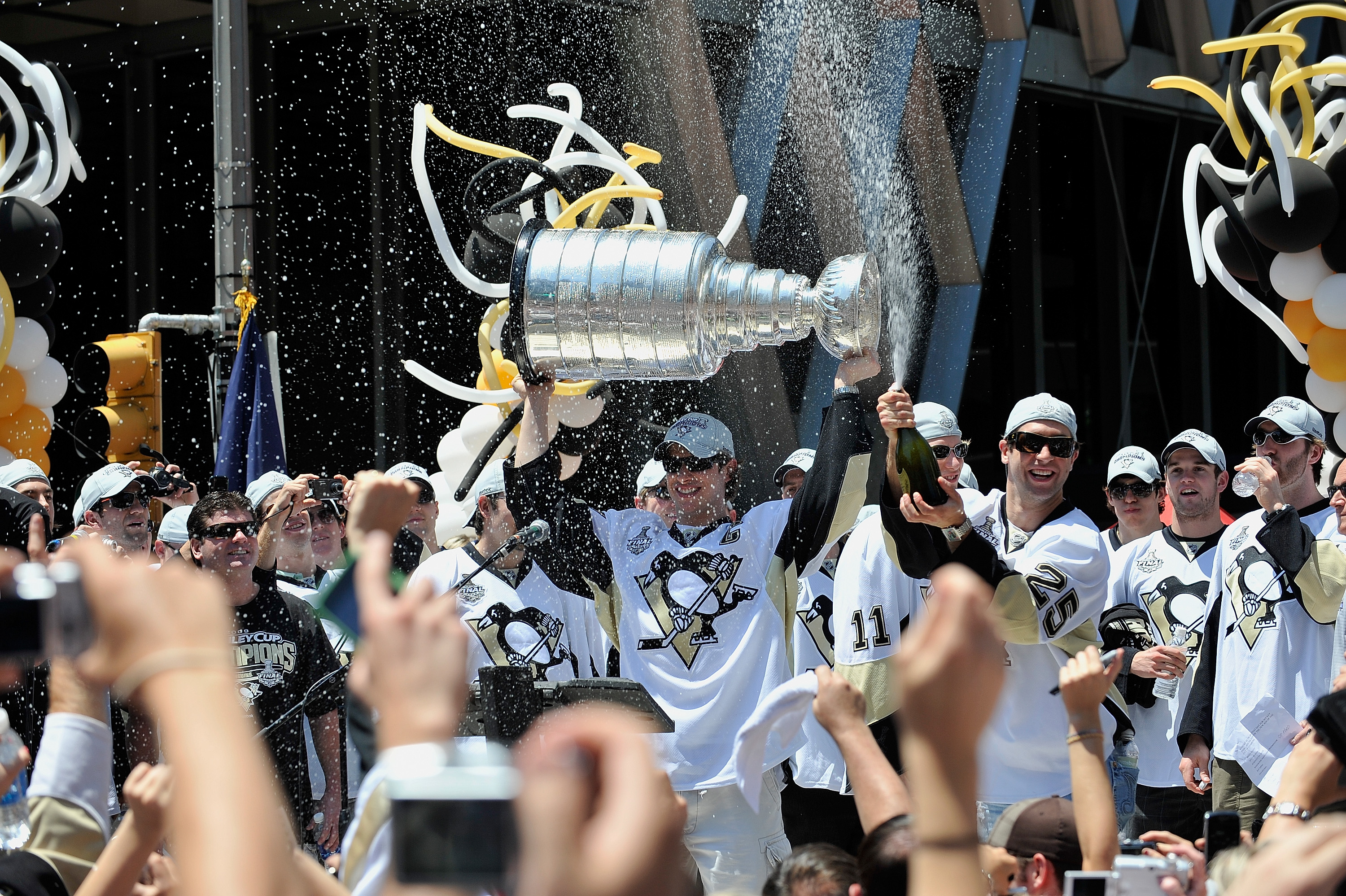 PITTSBURGH - JUNE 15:  Sidney Crosby #87 of the Pittsburgh Penguins holds the Stanley Cup as Maxime Talbot #25 of the Penguins sprays the crowd during Stanley Cup Champion Victory Parade on June 15, 2009 in Pittsburgh, Pennsylvania.  (Photo by Jamie Sabau