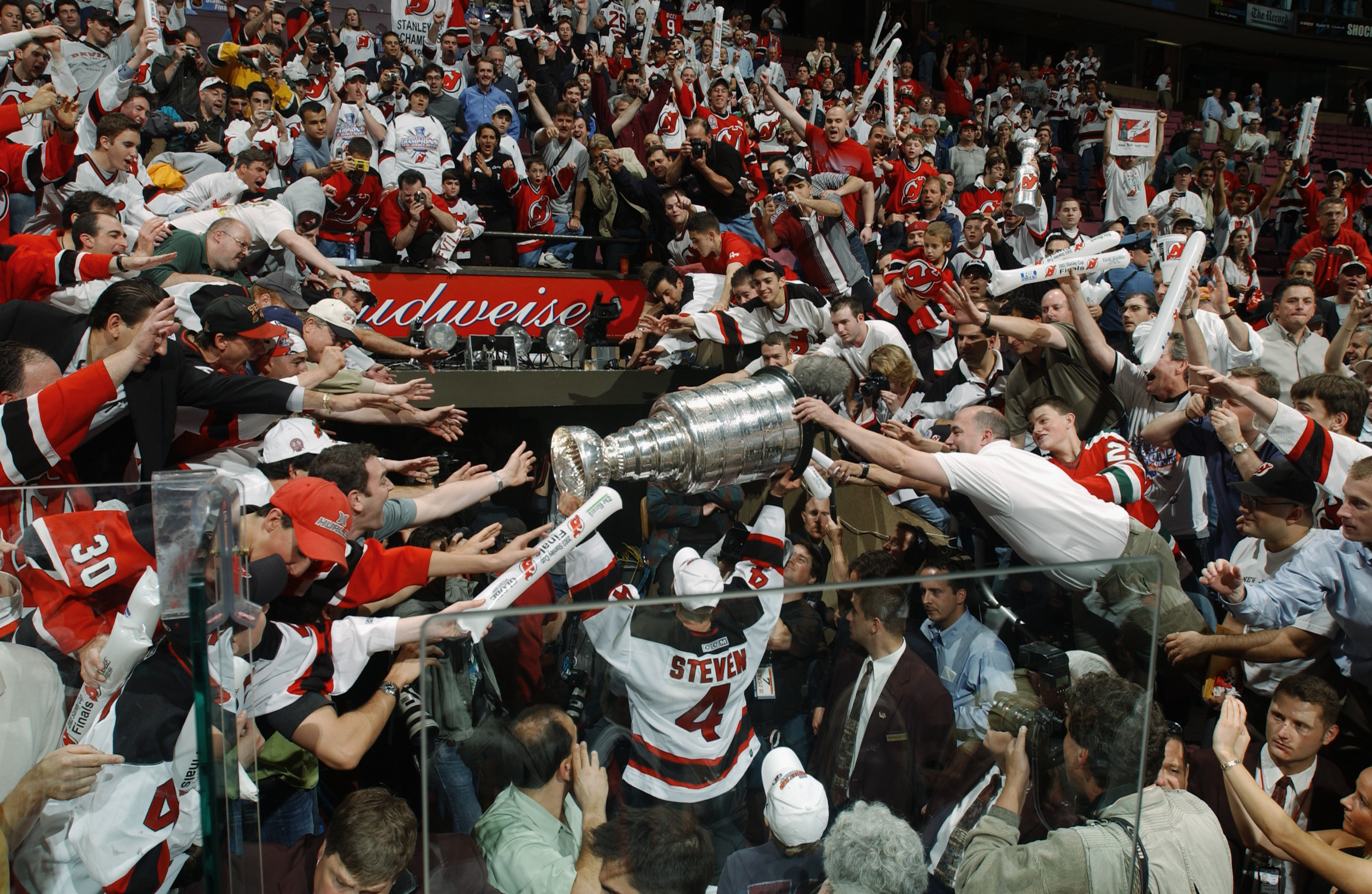 EAST RUTHERFORD, NJ - JUNE 9:  Scott Stevens of the New Jersey Devils carries the Stanley Cup holds up the Stanley Cup after beating the Mighty Ducks of Anaheim in game seven of the 2003 Stanley Cup Finals at Continental Airlines Arena on June 9, 2003 in