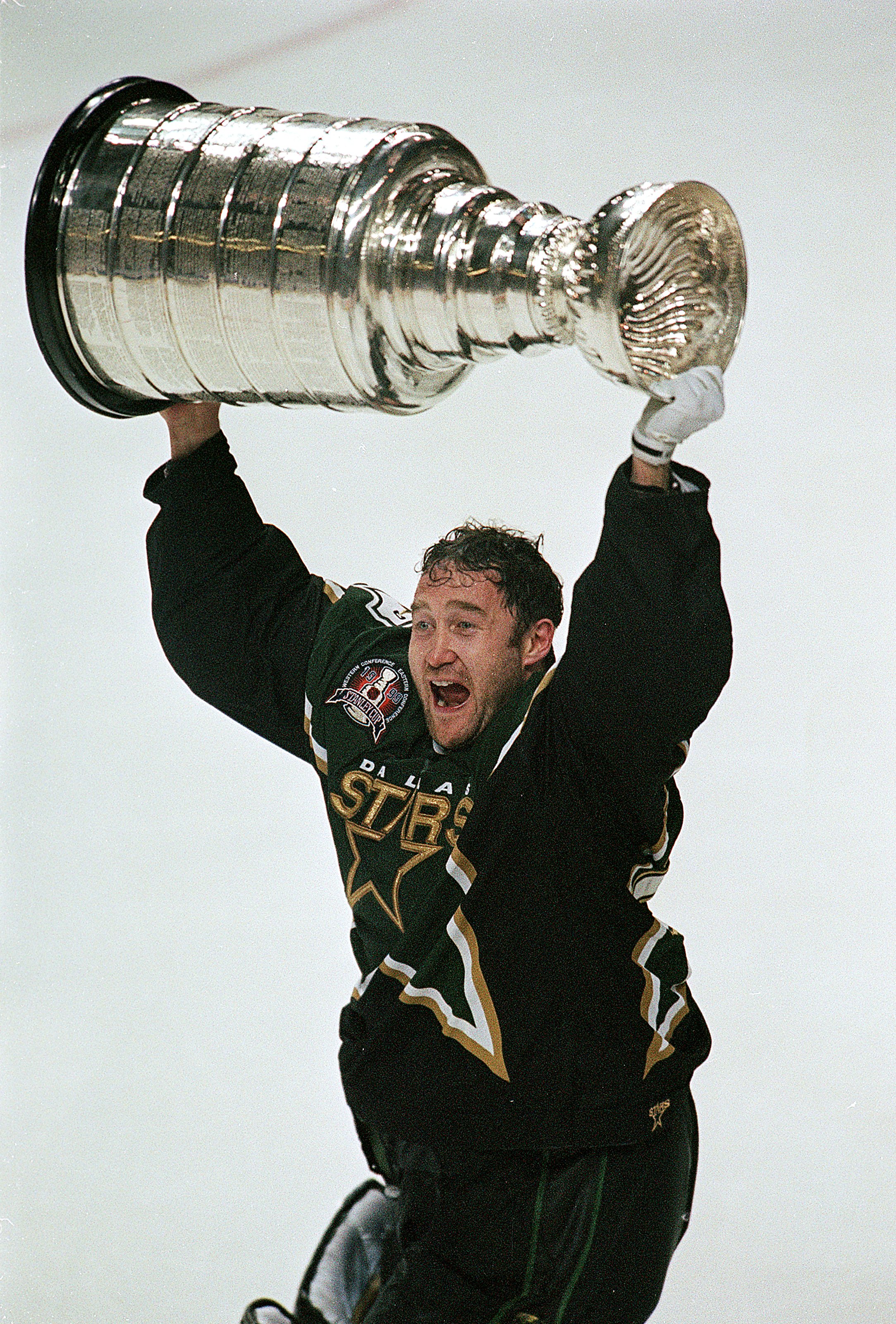 19 Jul 1999: Ed Belfour #20 of the Dallas Stars celebrates as he carries the Stanely Cup on the ice after the Stanley Cup Game against the Buffalo Sabres at the Marine Midland Arena in Buffalo, New York. The Stars defeated the Sabres 2-1 in the third over