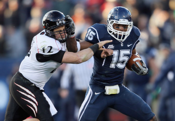 EAST HARTFORD, CT - NOVEMBER 27: Jerome Junior #15 of the Connecticut Huskies is tackled by Zach Collaros #12 of the Cincinnati Bearcats after Junior intercepted Collaros' pass in the fourth quarter on November 27, 2010 at Rentschler Field in East Hartfo