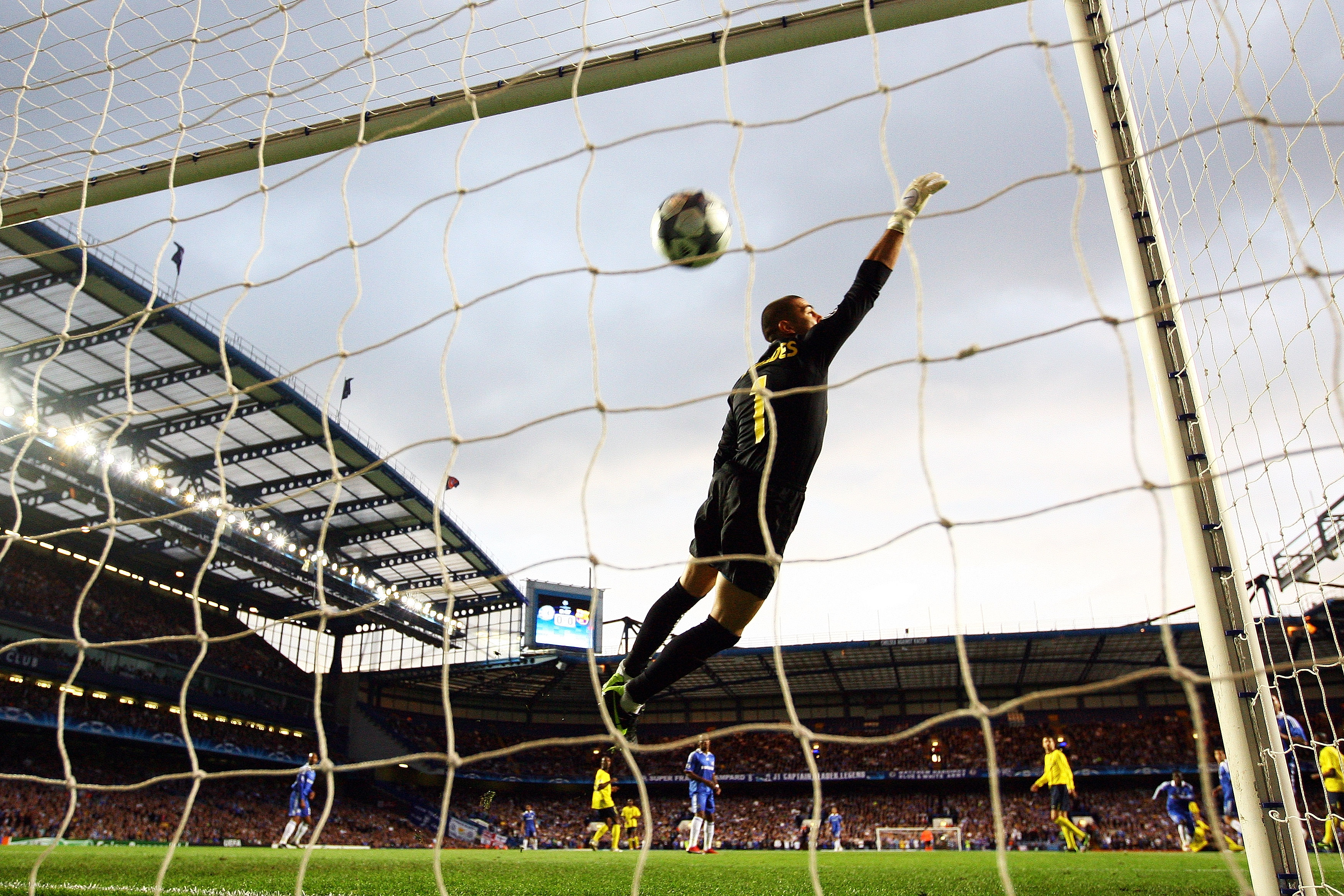 LONDON, ENGLAND - MAY 06:  Victor Valdes of Barcelona dives but can not stop the shot from Michael Essien of Chelsea scoring the first goal of the game during the UEFA Champions League Semi Final Second Leg match between Chelsea and Barcelona at Stamford