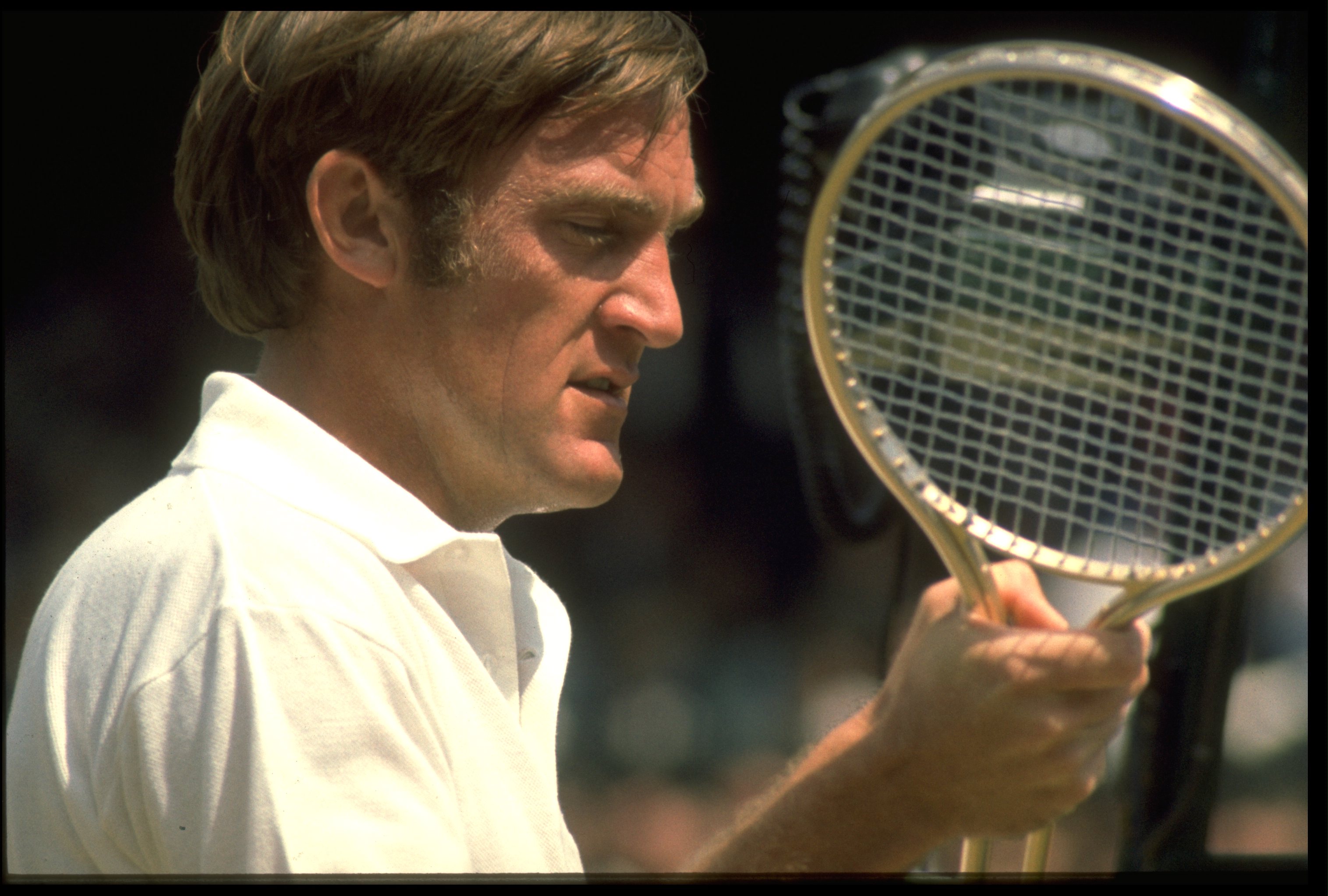 1970's:  TONY ROCHE OF AUSTRALIA EXAMINES HIS RACQUET DURING A MATCH AT THE WIMBLEDON TENNIS CHAMPIONSHIPS.