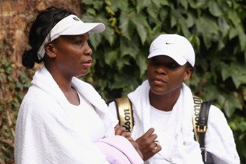 WIMBLEDON, ENGLAND - JUNE 18:  Venus Williams (L) and Serena Williams conclude their training session on the Aorangi Practice court at the All England Lawn Tennis and Croquet Club ahead of the Wimbledon Lawn Tennis Championships on June 18, 2011 in London