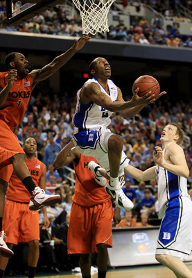GREENSBORO, NC - MARCH 12:  Nolan Smith #2 of the Duke Blue Devils shoots against Terrell Bell #1 of the Virginia Tech Hokies as teammate Kyle Singler #12 looks on during the first half in the semifinals of the 2011 ACC men's basketball tournament at the