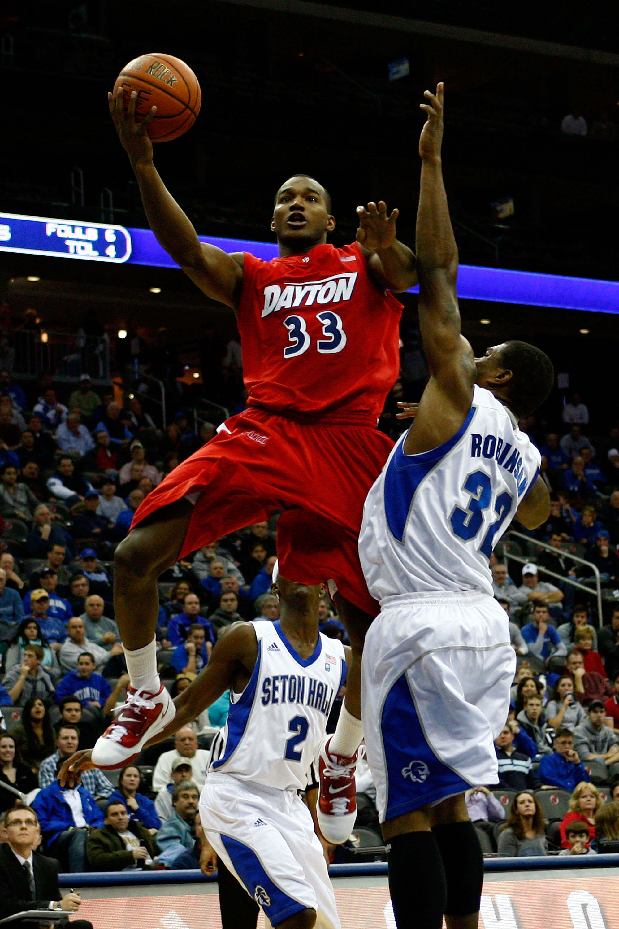NEWARK, NJ - DECEMBER 22:  Chris Wright #33 of the Dayton Flyers drives for a shot attempt against Jeff Robinson #32 of the Seton Hall Pirates at Prudential Center on December 22, 2010 in Newark, New Jersey.  (Photo by Chris Chambers/Getty Images)