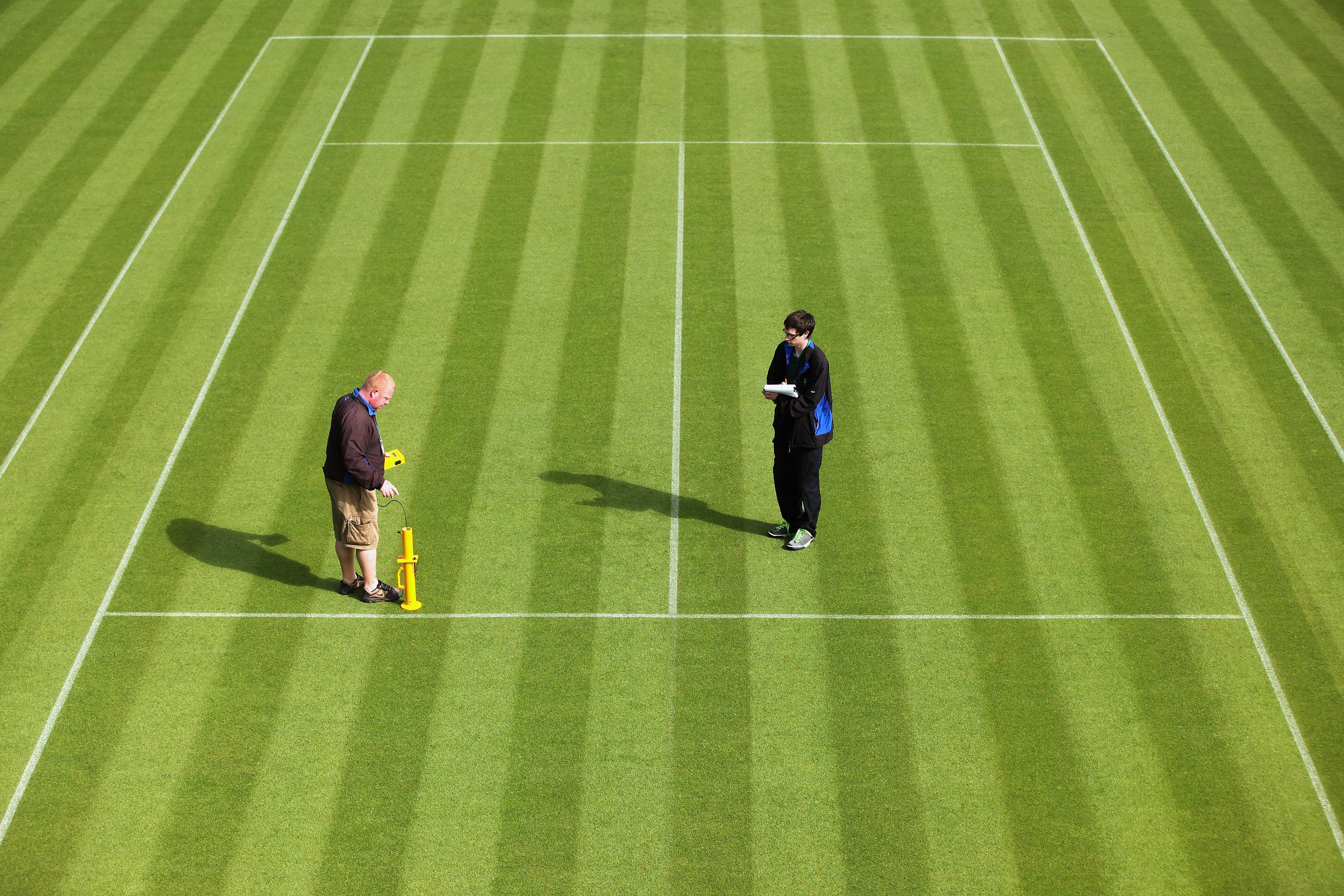 WIMBLEDON, ENGLAND - JUNE 18:  Groundstaff use an instrument to check the bounciness of the grass courts at the All England Lawn Tennis and Croquet Club ahead of the Wimbledon Lawn Tennis Championships on June 18, 2011 in London, England. The Championship