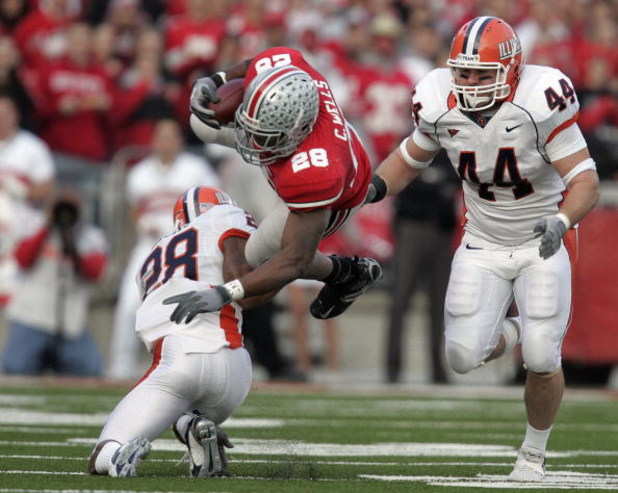COLUMBUS - NOVEMBER 10: Chris Wells #28 of the Ohio State Buckeyes is tackled by Dere Hicks #28 of the Illinois Fighting Illini as Illinois player Brit Miller #44 looks on during the first quarter at Ohio Stadium November 10, 2007 in Columbus, Ohio. Illi
