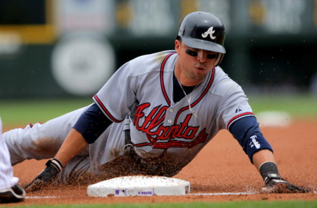 DENVER - JULY 12:  Martin Prado #14 of the Atlanta Braves slides into thirdbase on a Garret Anderson single in the first inning against the Colorado Rockies during MLB action at Coors Field on July 12, 2009 in Denver, Colorado. Prado went on to score on a