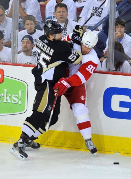PITTSBURGH - JUNE 09: Johan Franzen #93 of the Detroit Red Wings is checked into the boards by Sergei Gonchar #55 of the Pittsburgh Penguins during Game Six of the NHL Stanley Cup Finals at the Mellon Arena on June 9, 2009 in Pittsburgh, Pennsylvania. (