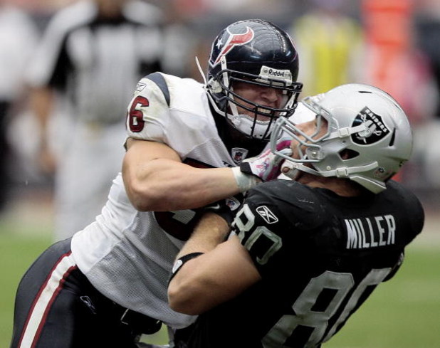 HOUSTON - OCTOBER 04:  Linebacker Brian Cushing #56 of the Houston Texans delivers a hard hit to tight-end Zach Miller #80 of the Oakland Raiders at Reliant Stadium on October 4, 2009 in Houston, Texas.  (Photo by Bob Levey/Getty Images)