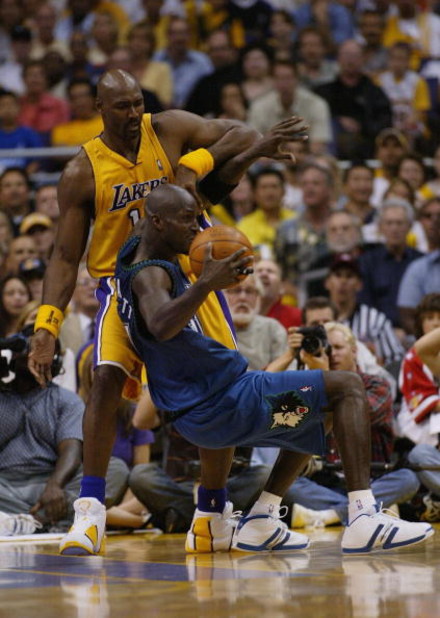 LOS ANGELES - MAY 31:  Kevin Garnett #21 of the Minnesota Timberwolves loses his balance against Karl Malone #11 of the Los Angeles Lakers in Game six of the Western Conference Finals during the 2004 NBA Playoffs on May 31, 2004 at Staples Center in Los A