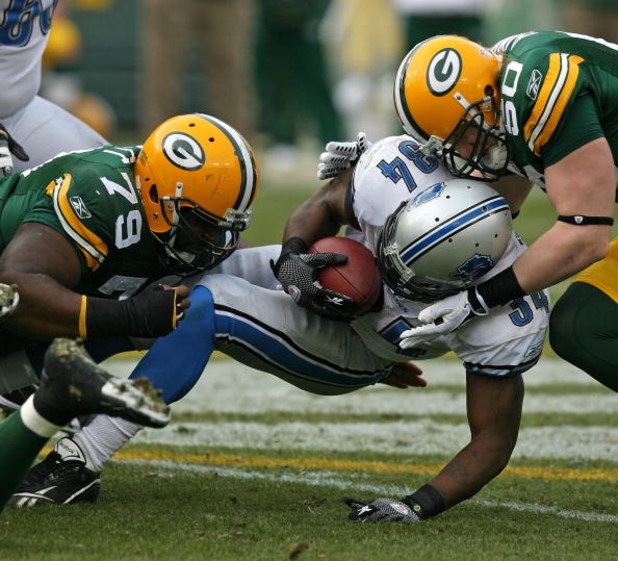 GREEN BAY, WI - OCTOBER 18: Kevin Smith #34 of the Detroit Lions is tackled by Ryan Pickett #79 and A.J. Hawk #50 of the Green Bay Packers at Lambeau Field on October 18, 2009 in Green Bay, Wisconsin. The Packers defeated the Lions 26-0. (Photo by Jonatha