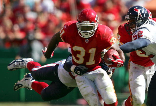 KANSAS CITY, MO - SEPTEMBER 26: Runningback Priest Holmes #31 of the Kansas City Chiefs breaks through the tackles of Jay Foreman #56 and Kailee Wong #52 of the Houston Texans as he scrambles under pressure during the 4th quarter of their NFL game on Sept